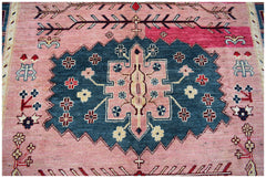 Handmade Afghan Pashm rug featuring a central blue medallion with floral motifs on a pink field.