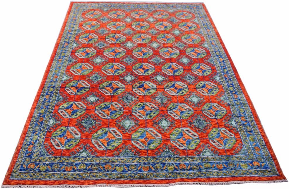 A handmade Afghan wool rug featuring a repeating geometric pattern in orange, blue, and green.