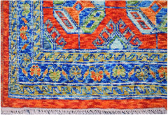 Handmade Afghan wool rug featuring a vibrant geometric tribal pattern in orange, blue, and green.