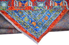 A handmade Afghan Pashm wool rug featuring a vibrant blue and orange geometric tribal pattern.