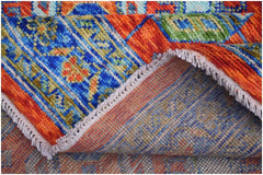 A handmade Afghan wool rug featuring a vibrant, colorful geometric tribal pattern.