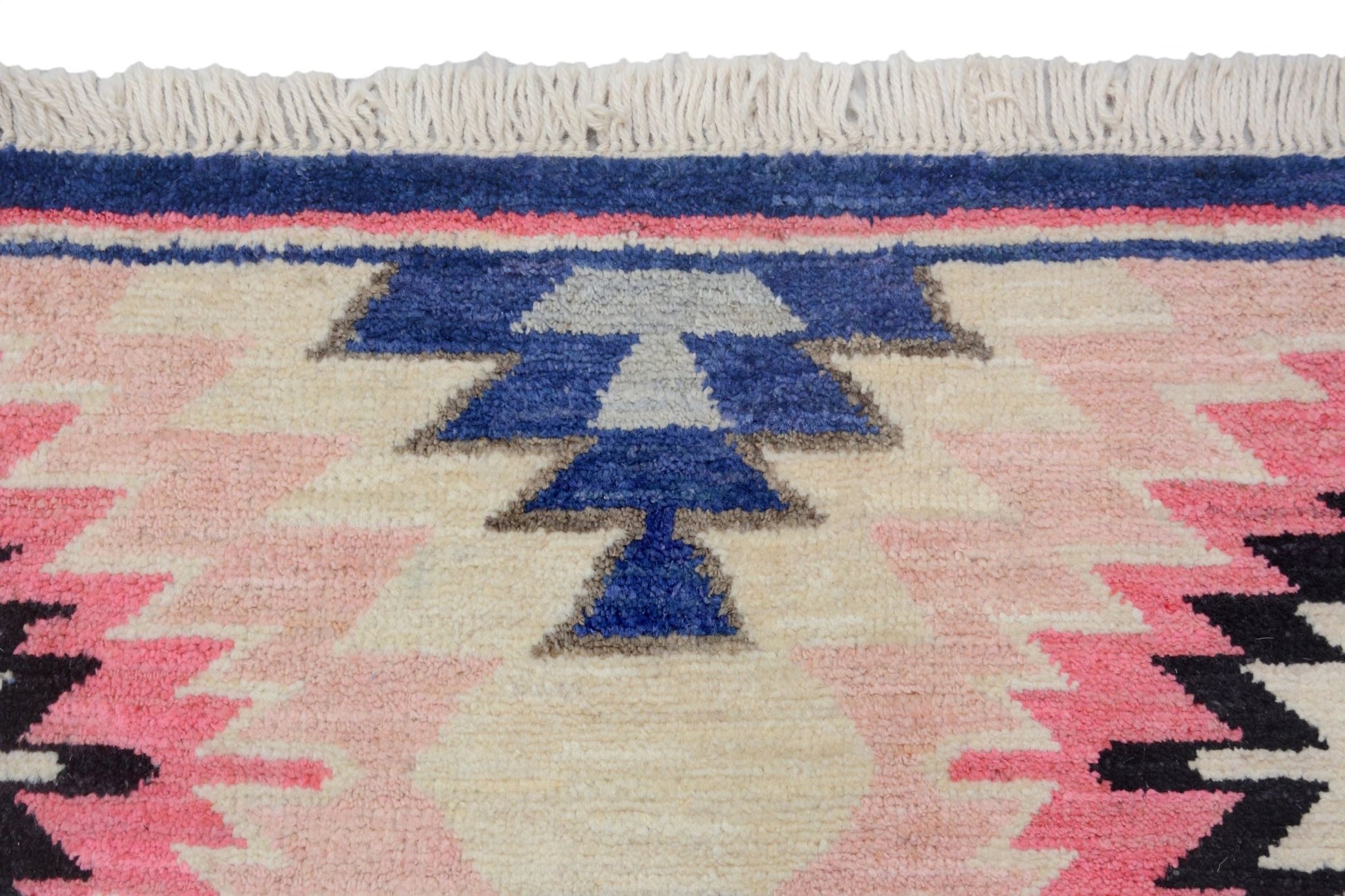 A handmade Afghan wool rug featuring a geometric tribal pattern in pink, blue, and cream tones.