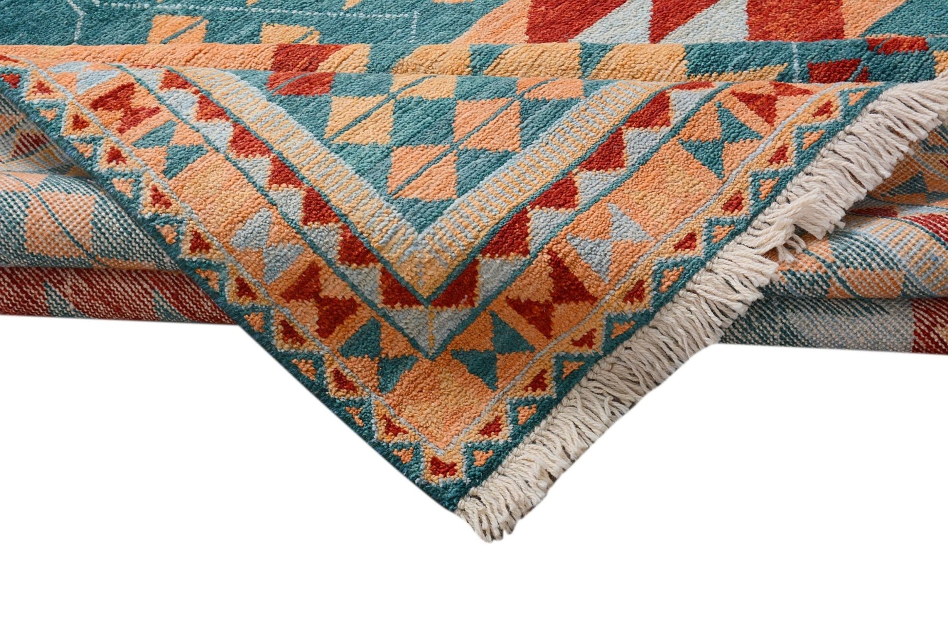 A handmade Afghan wool rug featuring a geometric tribal pattern in teal, orange, and red.