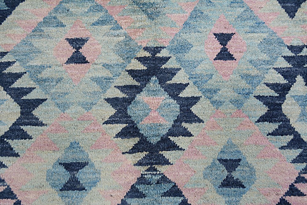 Handmade Afghan wool rug featuring a geometric diamond pattern in shades of blue and soft pink.