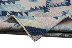 A handmade Afghan wool rug featuring a geometric pattern in shades of blue, pink, and cream.