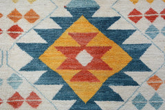 Handmade Afghan wool rug featuring a geometric tribal pattern in blue, yellow, and orange.