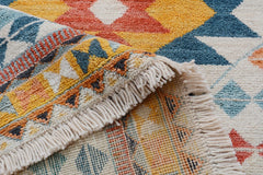 A handmade Afghan wool rug featuring a colorful geometric tribal pattern and fringed edges.