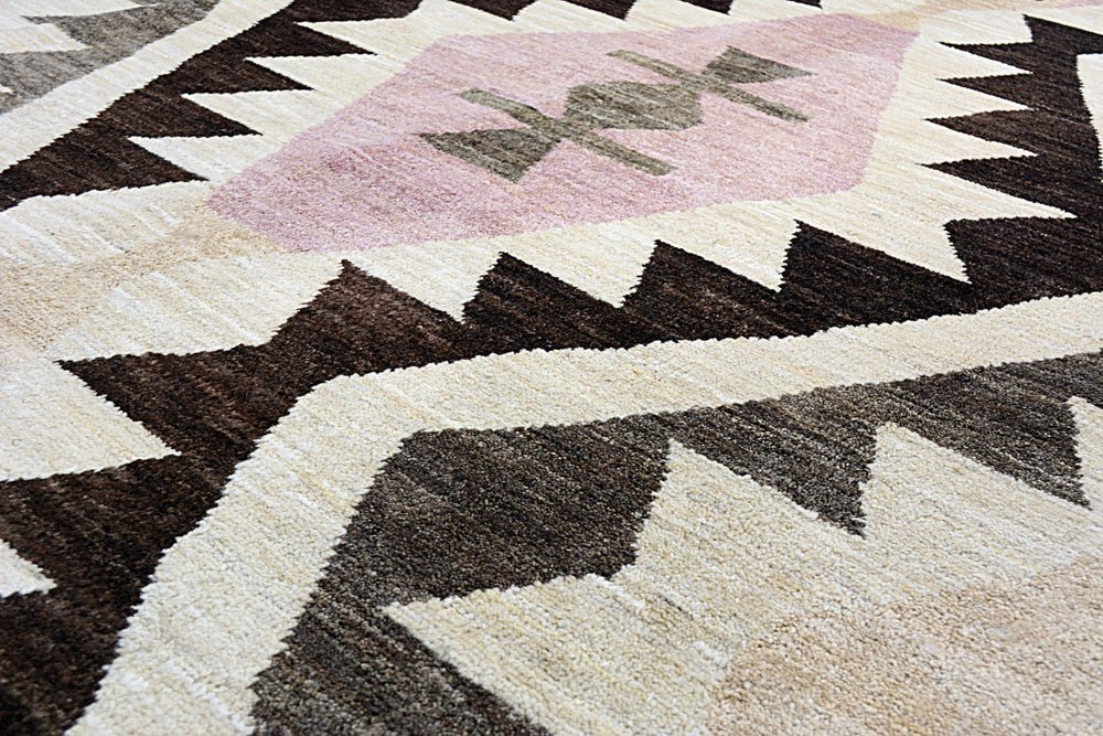 Handmade Afghan wool rug featuring a geometric pattern in brown, cream, and soft pink.