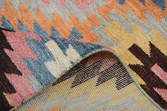 A handmade Afghan Pashm rug featuring a colorful geometric kilim pattern and a plush wool pile.