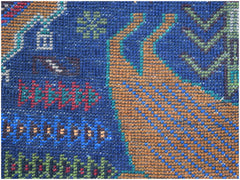A close-up of a handmade Afghan wool runner featuring a detailed hunting scene on a blue background.