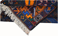 A handmade Afghan wool runner featuring a colorful geometric hunting scene and tasseled ends.
