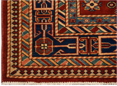 A handmade Afghan Super Kazakh rug featuring traditional geometric motifs in red and blue.