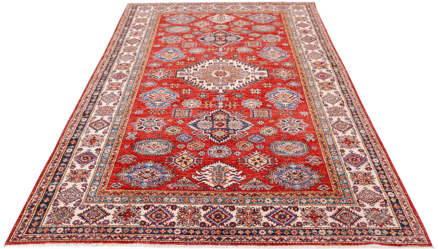Handmade Afghan Super Kazakh rug featuring traditional geometric motifs in red, blue, and cream.