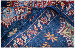 A close-up of a handmade Afghan Kazakh rug featuring traditional geometric patterns in blue and red.