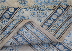 A handmade Afghan Super Kazakh rug featuring traditional blue and cream floral patterns.