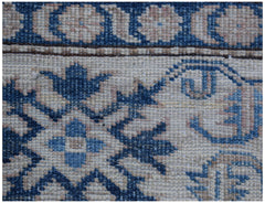 A close-up of an Afghan Super Kazakh rug featuring traditional blue and cream geometric patterns.