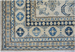 Handmade Afghan Super Kazakh rug featuring traditional blue geometric motifs on a cream background.