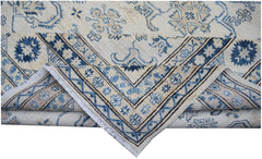 A handmade Afghan Super Kazakh rug featuring traditional blue and beige floral motifs.