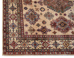 Handmade Afghan Super Kazakh rug featuring traditional geometric motifs in red, blue, and tan.