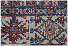 A handmade Afghan Super Kazakh rug featuring traditional geometric motifs in red, blue, and tan.