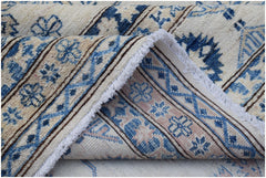 A handmade Afghan Super Kazakh rug featuring traditional blue and cream geometric patterns.