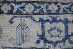 A close-up of an Afghan Super Kazakh rug featuring traditional blue geometric motifs on cream wool.