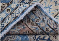 A handmade Afghan Super Kazakh wool rug featuring traditional blue and cream geometric patterns.