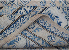 A handmade Afghan Super Kazakh rug featuring traditional blue geometric motifs on a cream background.