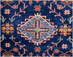 Handmade Afghan Kazakh rug featuring a central geometric cross motif on a deep blue field.