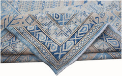 A handmade Afghan Super Kazakh rug featuring traditional blue and cream geometric patterns.