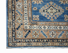 A handmade Afghan Super Kazakh runner rug featuring traditional geometric motifs in blue and tan.