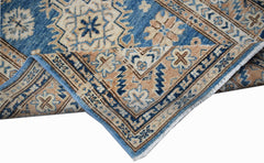 A handmade Afghan Super Kazakh runner featuring traditional geometric motifs in blue and tan.