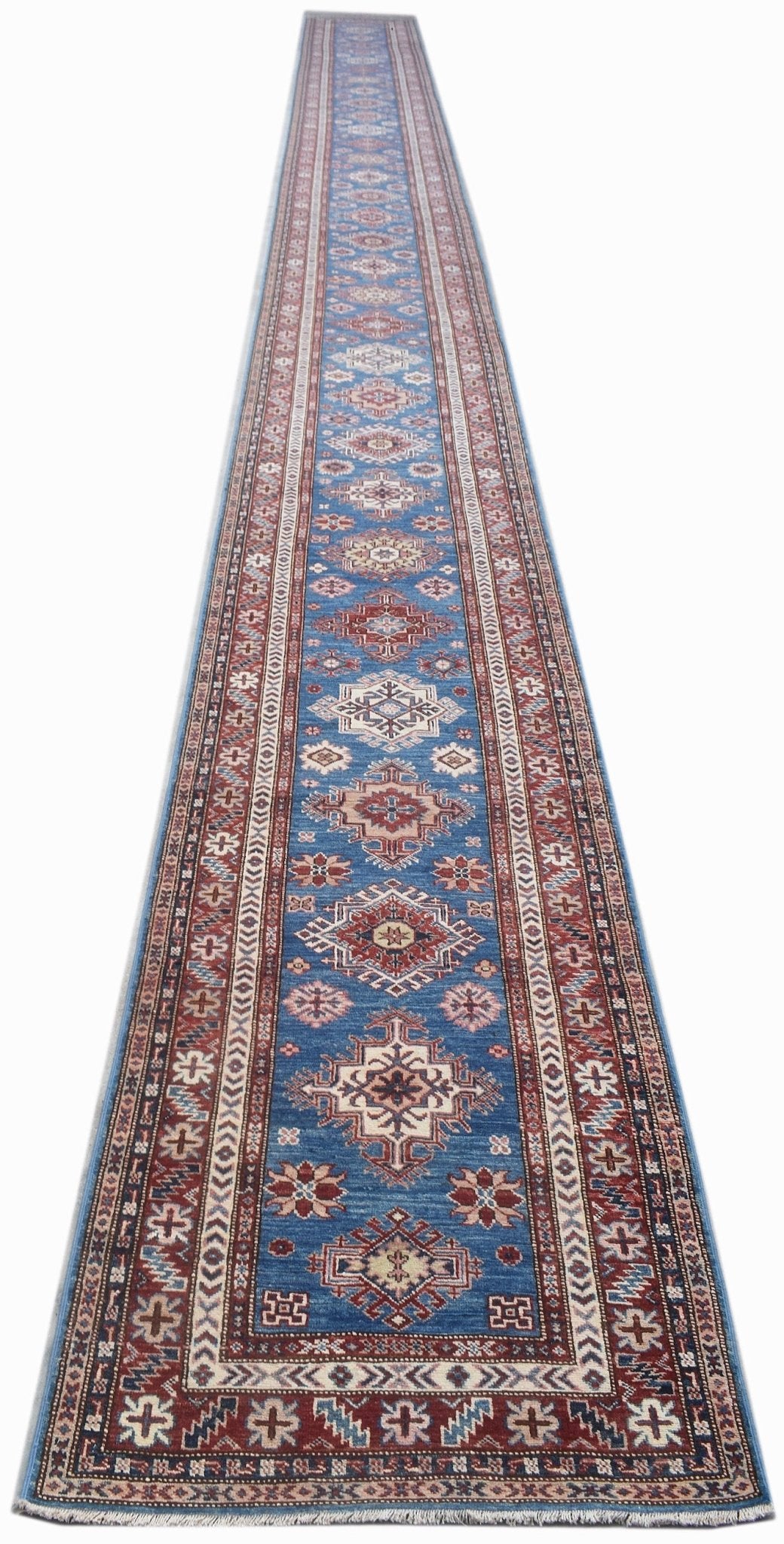 A long, handmade Afghan Super Kazakh runner rug featuring traditional geometric motifs in blue.