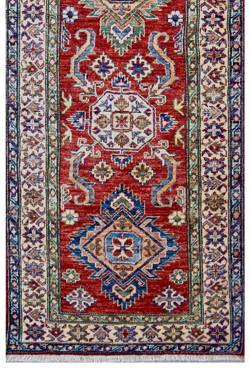 Handmade Afghan Super Kazakh runner rug featuring geometric medallions on a red wool field.