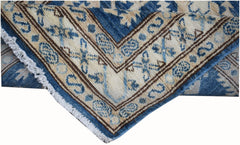 A handmade Afghan Super Kazakh runner featuring traditional blue and cream geometric patterns.