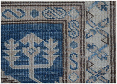 A close-up of an Afghan Super Kazakh runner featuring traditional blue and beige geometric motifs.