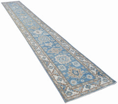 A long, handmade Afghan Super Kazakh runner rug featuring traditional blue and beige patterns.