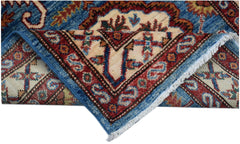 A folded Afghan Super Kazakh runner featuring traditional geometric motifs in blue and red wool.