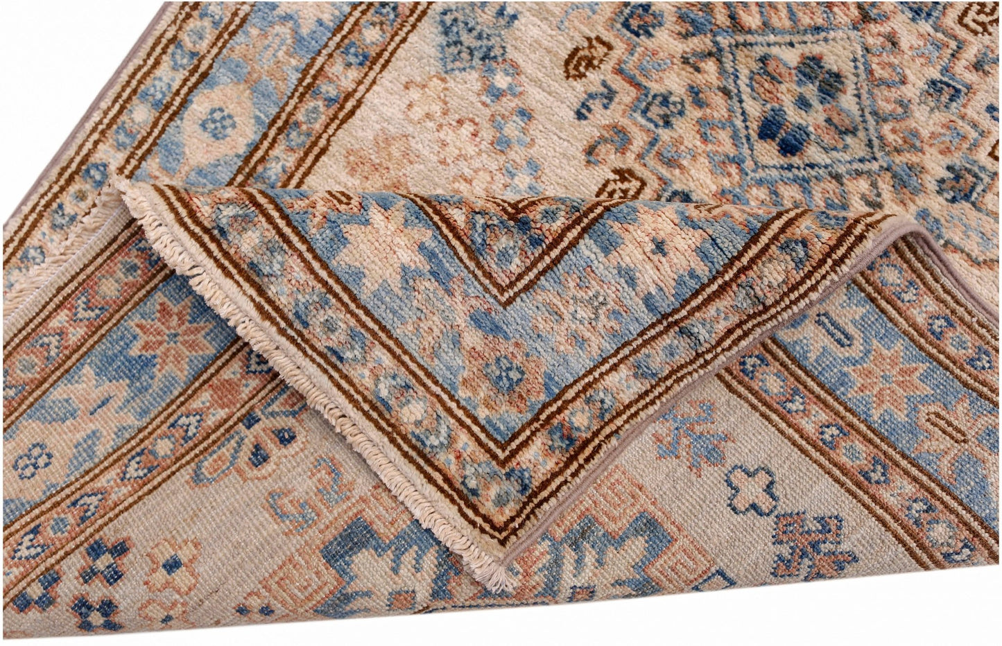 A folded Afghan Super Kazakh runner featuring traditional blue and tan geometric patterns.