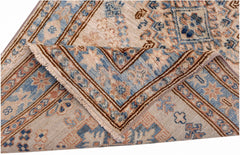 A folded Afghan Super Kazakh runner featuring traditional blue and tan geometric patterns.