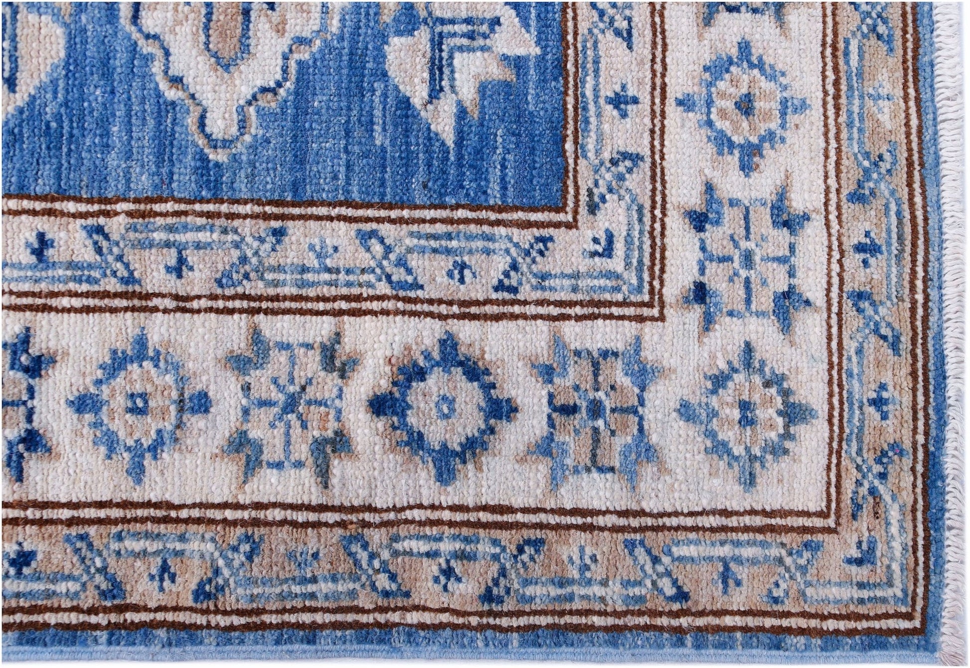 A handmade Afghan Super Kazakh runner featuring traditional blue and beige geometric motifs.