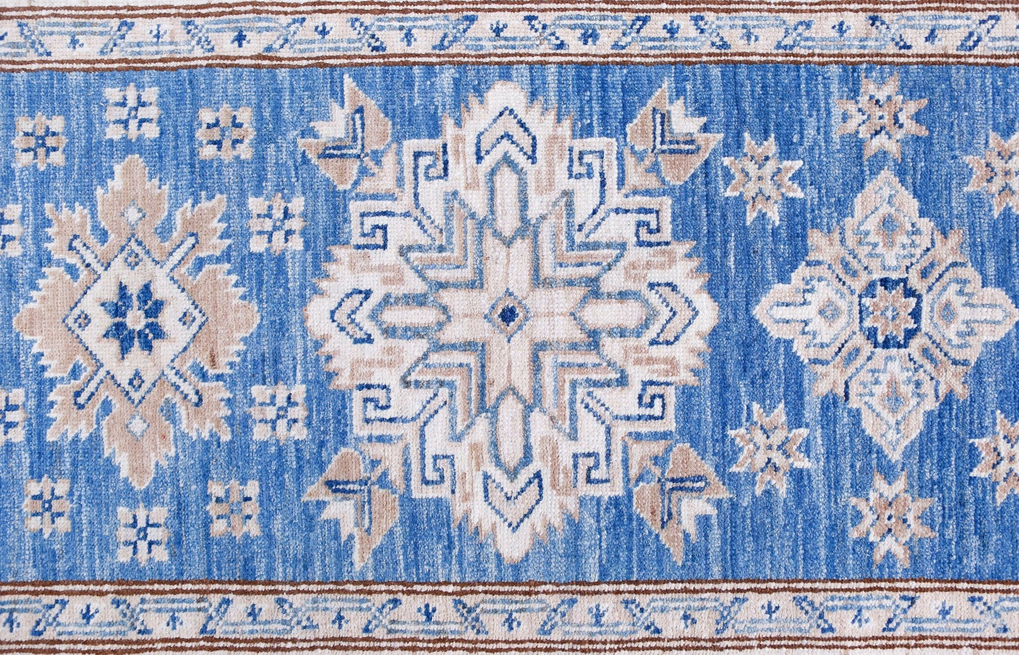 An Afghan Super Kazakh runner featuring traditional geometric motifs in blue, beige, and white.