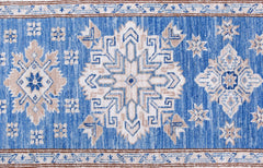 An Afghan Super Kazakh runner featuring traditional geometric motifs in blue, beige, and white.