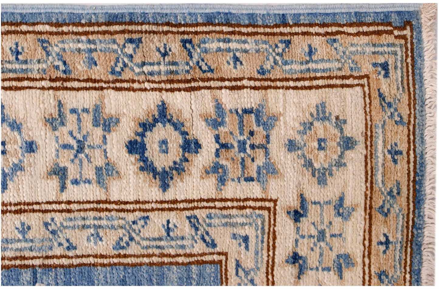 A close-up of an Afghan Super Kazakh runner featuring traditional blue and beige geometric motifs.