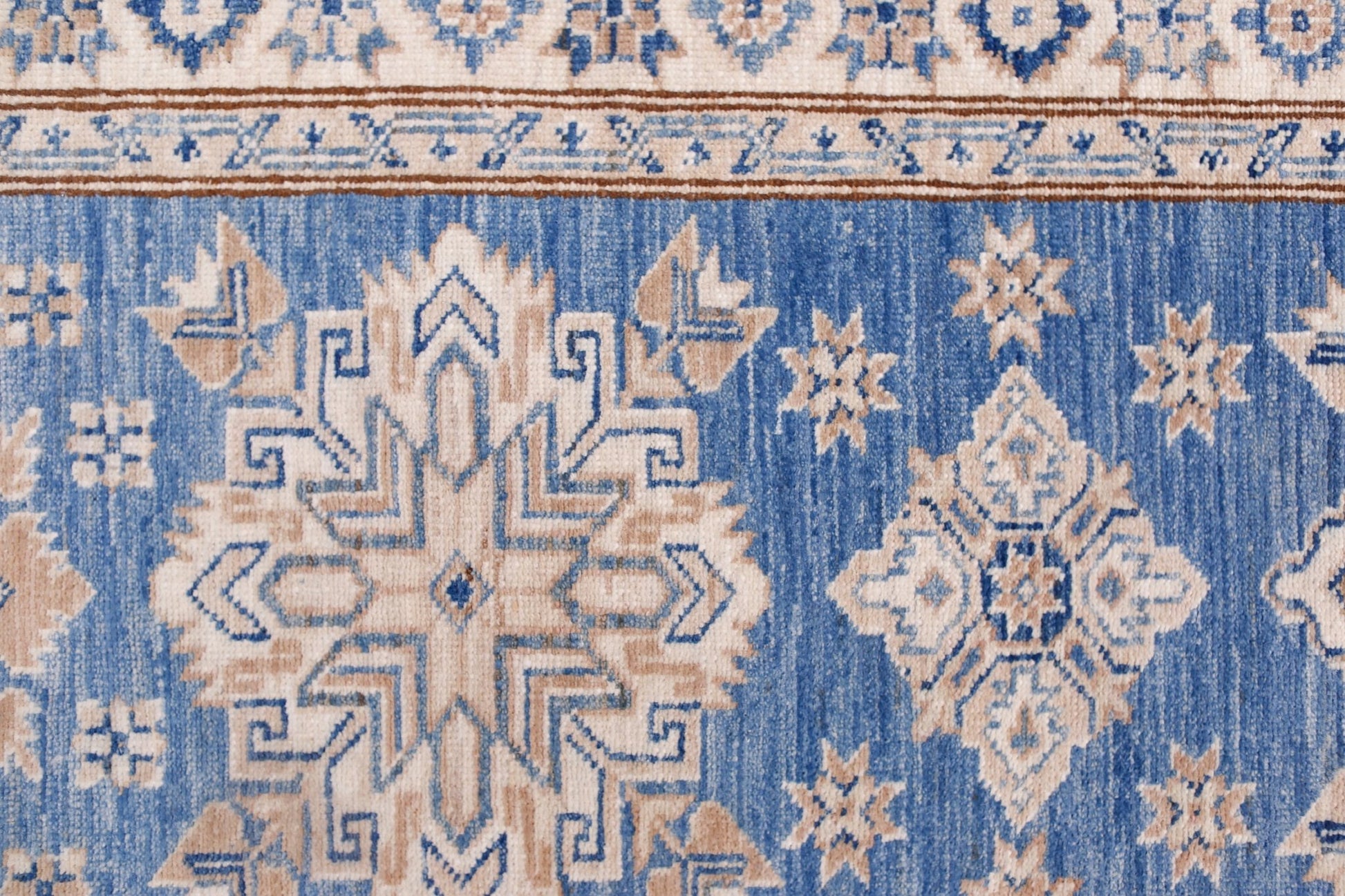An Afghan Super Kazakh runner featuring traditional geometric motifs in blue and beige wool.