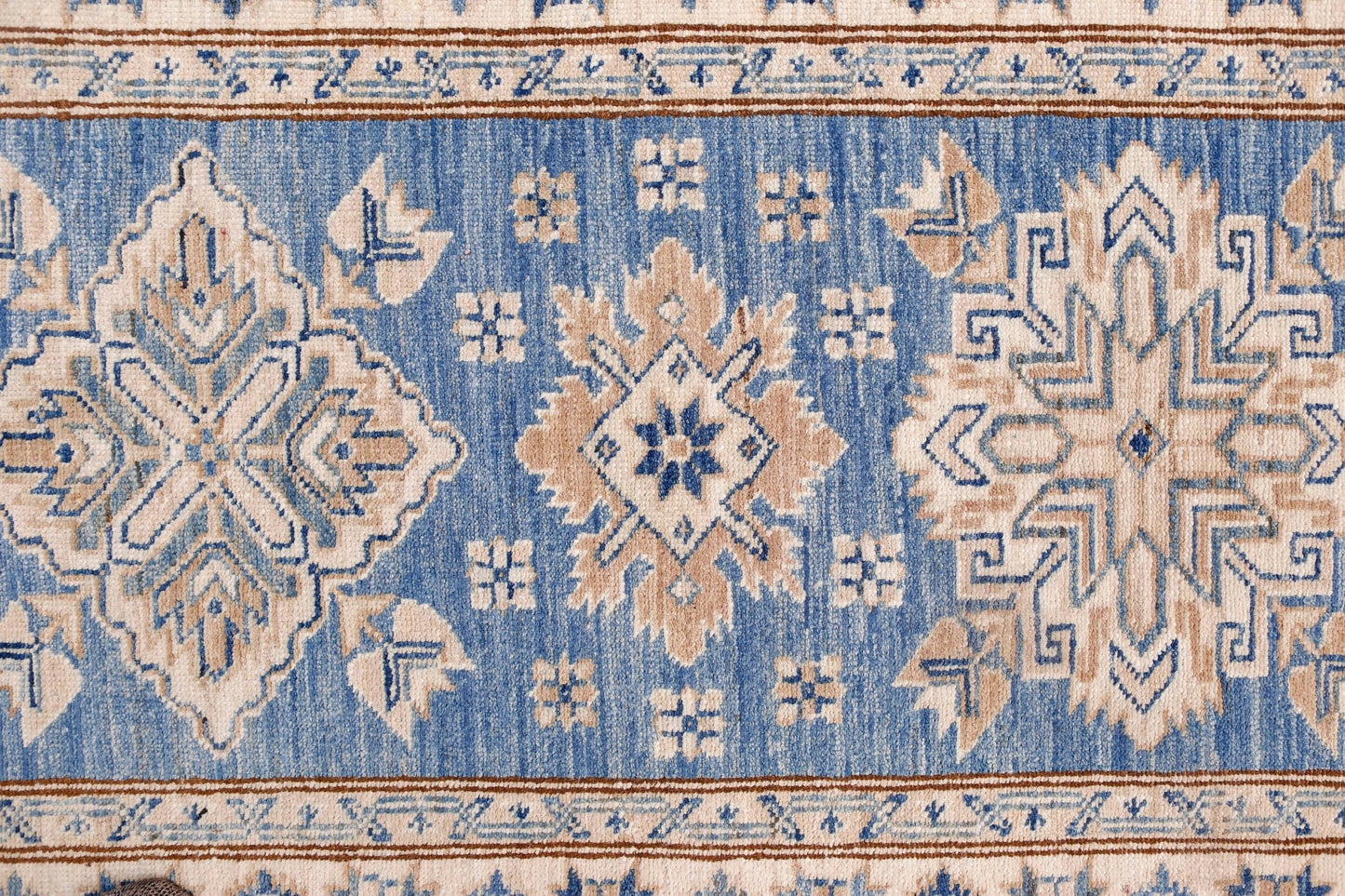 An Afghan Super Kazakh runner featuring traditional geometric motifs in blue, beige, and cream.