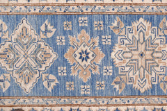 An Afghan Super Kazakh runner featuring traditional geometric motifs in blue, beige, and cream.