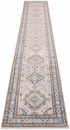 A long, handmade Afghan Super Kazakh runner rug featuring traditional blue and beige geometric motifs.