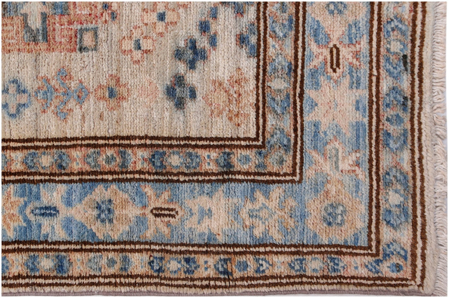 A handmade Afghan Super Kazakh runner featuring traditional blue and beige geometric floral motifs.