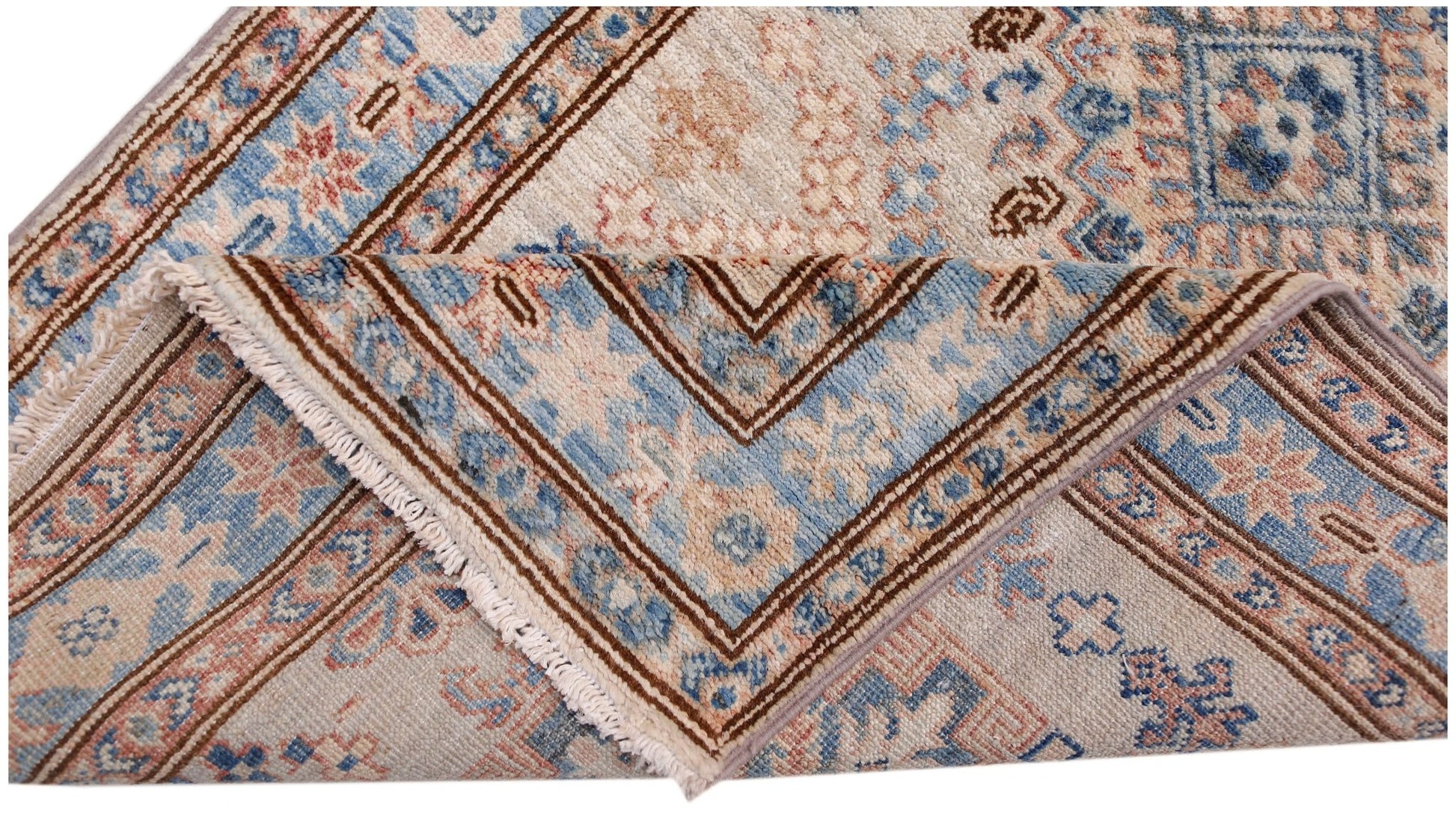 A folded Afghan Super Kazakh runner featuring traditional blue and beige geometric patterns.